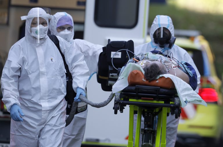 Zdravotníci prevážajú pacienta s ochorením Covid-19. Foto: TASR/AP