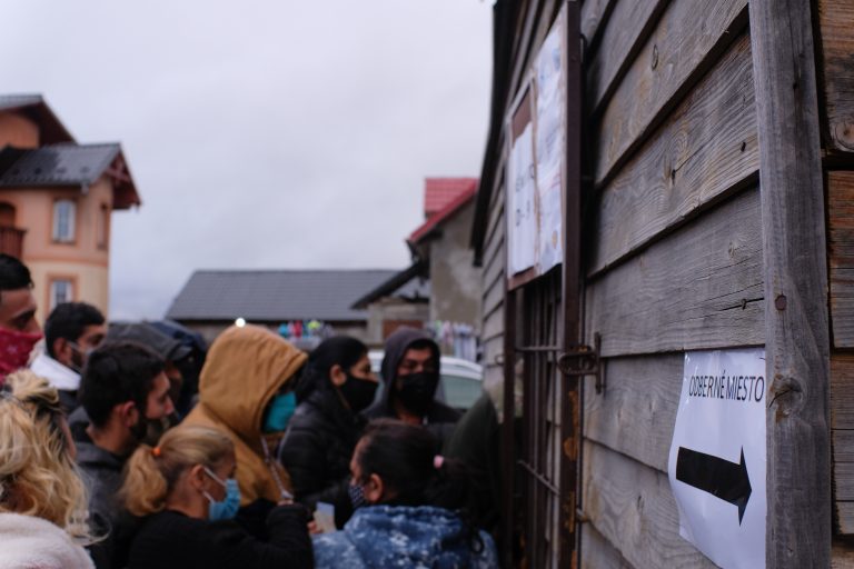 Rómovia v osade v Tatranskej Lomnici čakajú pred odbernou miestnosťou. Foto: Tony Frič