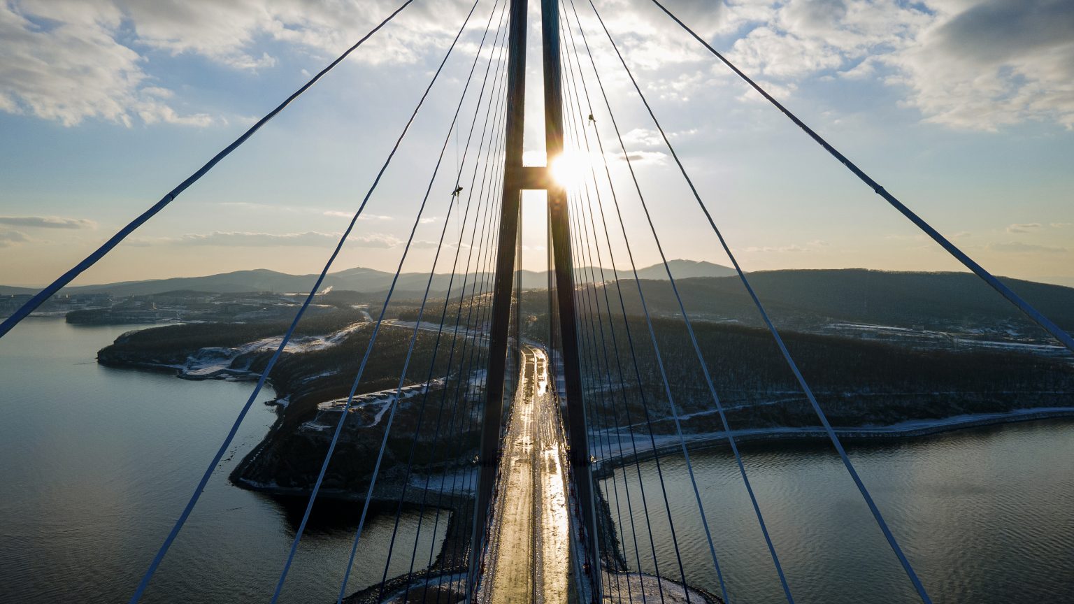 Horolezci odstraňujú ľad z lán Ruského mosta, ktorý vedie cez Bosporský prieliv v ruskom meste Vladivostok v pondelok 30. novembra 2020. Foto: TASR/AP
