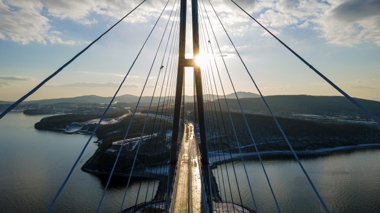 Horolezci odstraňujú ľad z lán Ruského mosta, ktorý vedie cez Bosporský prieliv v ruskom meste Vladivostok v pondelok 30. novembra 2020. Foto: TASR/AP
