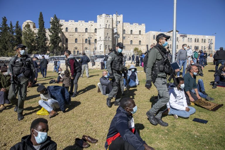 Izraelskí policajti vyzývajú moslimských veriacich, ktorí sa zhromaždili pri modlitbách, aby opustili verejné priestranstvo počas  lockdownu. Foto: TASR/AP