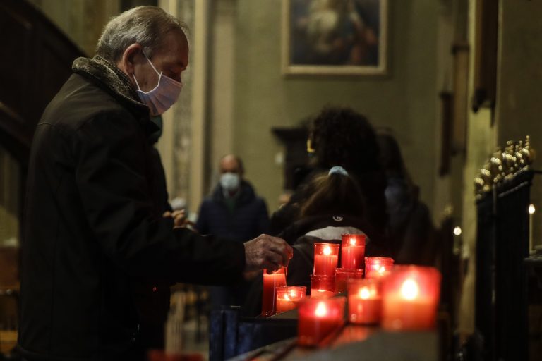 Muž zapaľuje sviečky počas bohoslužby v kostole - Ilustračný obrázok. Foto: TASR/AP