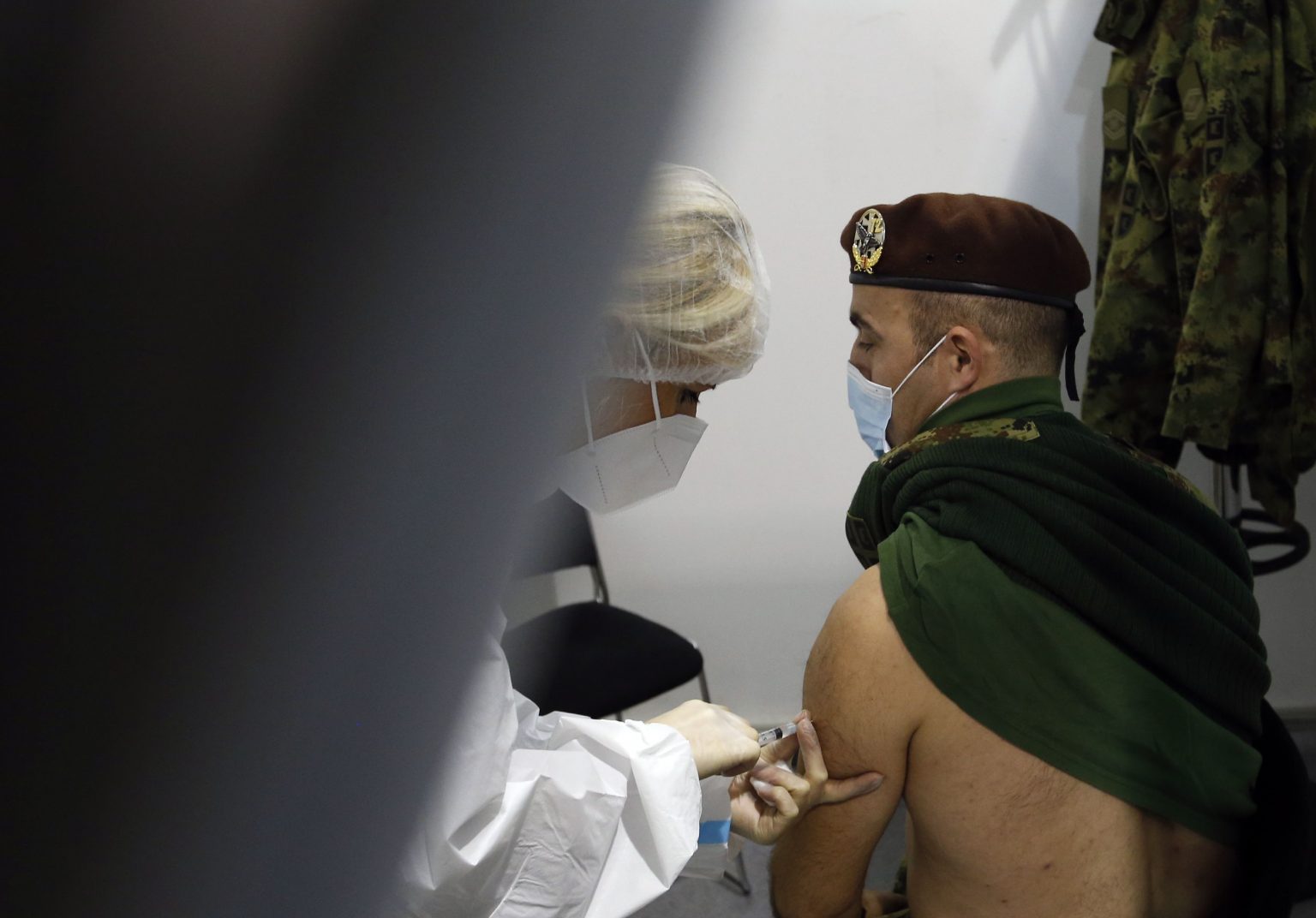 Vojak dostáva vakcínu proti ochoreniu COVID-19 od čínskej spoločnosti Sinopharm v Belehrade v utorok 19. januára 2021. Do Srbska doviezli v sobotu milión dávok vakcíny proti novému koronavírusu od čínskej spoločnosti Sinopharm. Srbsko sa tak stalo prvou európskou krajinou, do ktorej priviezli čínsku vakcínu určenú na masové očkovanie obyvateľstva. Foto: TASR/AP 