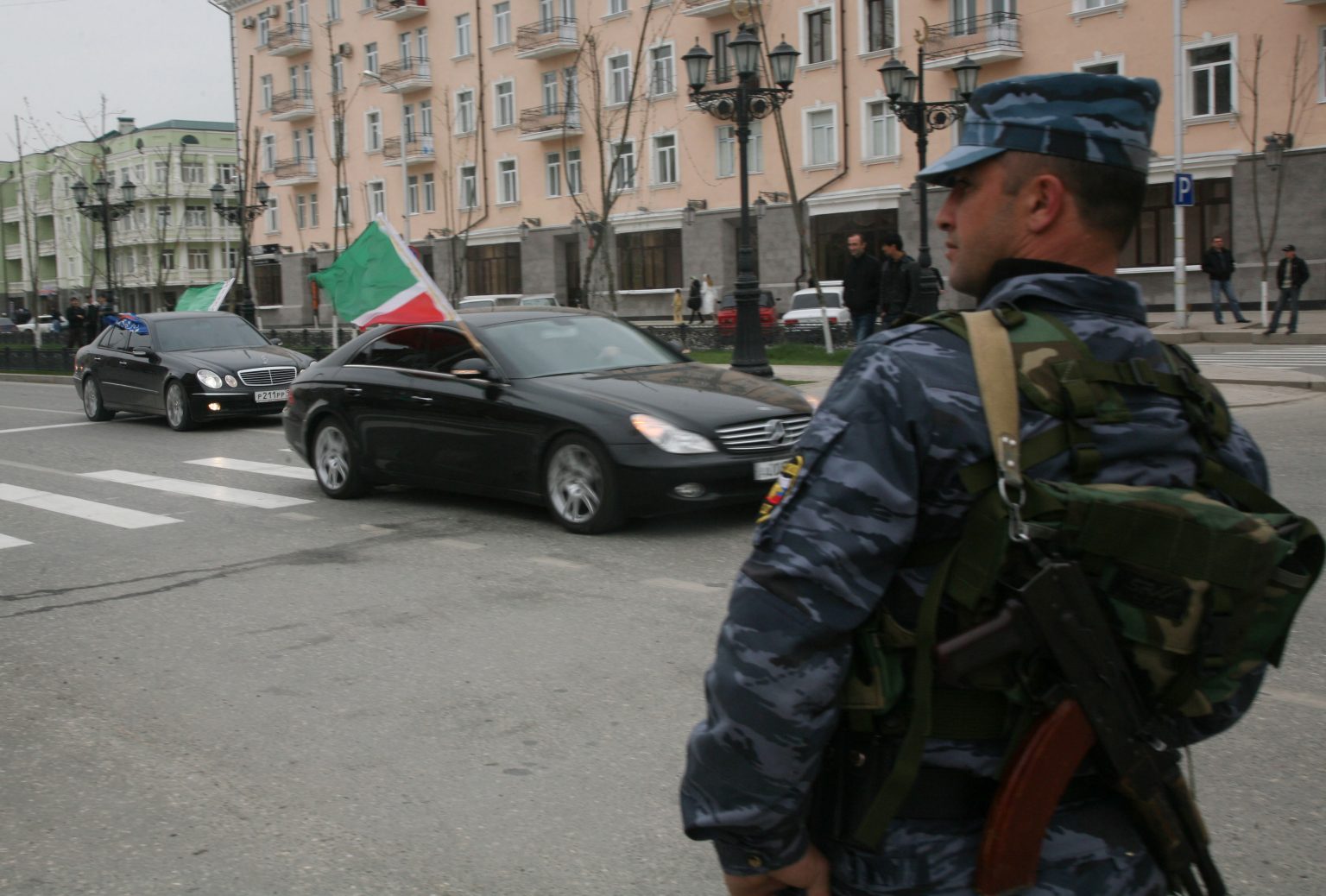 Policajt sa pozerá na autá s čečenskými zástavami v uliciach Grozného 16. apríla 2009 počas osláv zrušenia prísneho bezpečnostného režimu, ktorý platil v Čečensku počas uplynulých desiatich rokov. Foto: TASR/AP