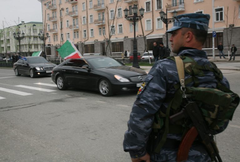 Policajt sa pozerá na autá s čečenskými zástavami v uliciach Grozného 16. apríla 2009 počas osláv zrušenia prísneho bezpečnostného režimu, ktorý platil v Čečensku počas uplynulých desiatich rokov. Foto: TASR/AP