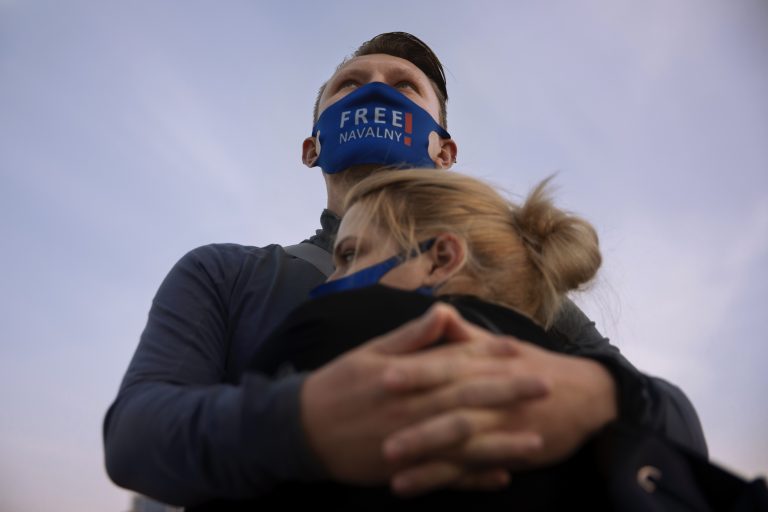 Pár s ochranným rúškom s nápisom "Prepustite Navaľného" počas protestu na podporu uväzneného vodcu ruskej opozície Alexeja Navaľného v Tel Avive. Foto: TASR/AP