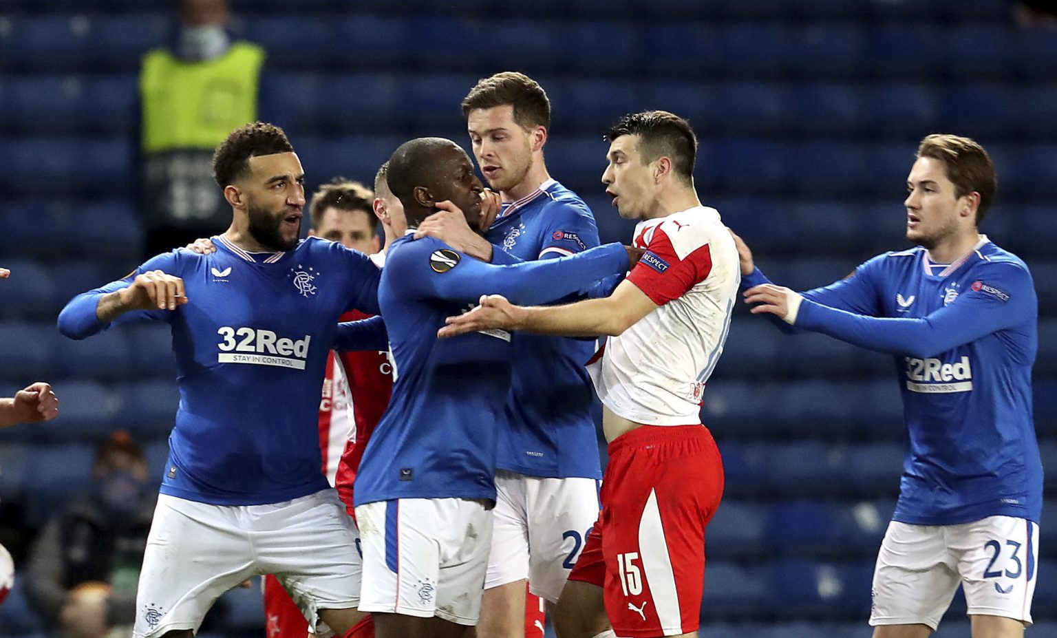 Fínsky stredopoliar Rangers Glen Kamara, napravo český obranca Slavie Ondřej Kúdela v hádke v odvete osemfinále Európskej ligy Glasgow Rangers - Slavia Praha v Glasgowe vo štvrtok 18. marca 2021.  Foto: TASR/AP