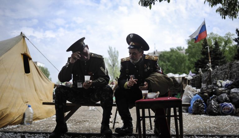 Proruskí kozáci obedujú pred budovu regionálnej vlády v Donecku 5. mája 2014.  Foto: TASR/AP