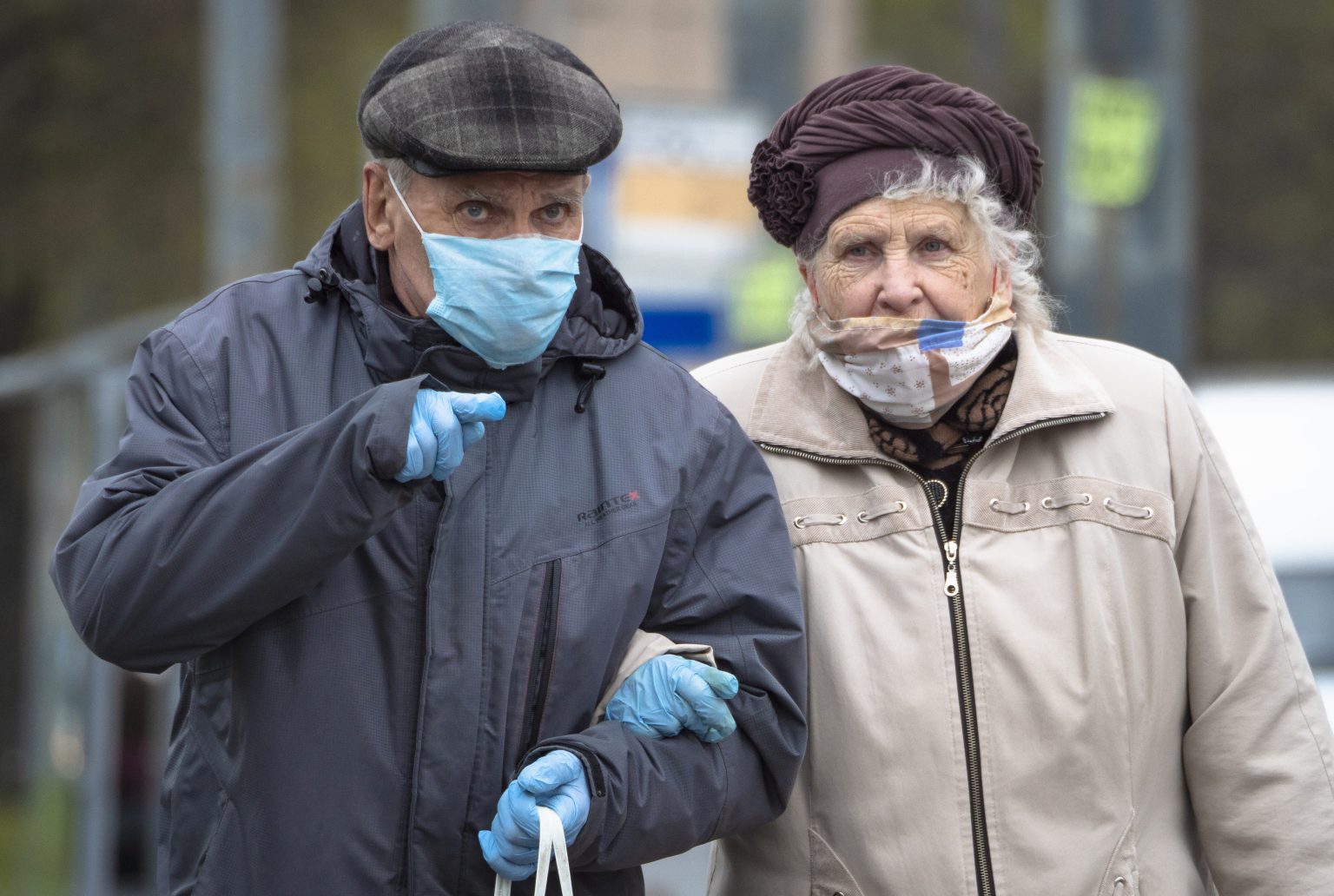 Seniori s ochrannými rúškami a rukavicami kráčajú po ulici v Petrohrade počas koronavírusovej pandémie. Ilustračný obrázok. Foto: TASR/AP