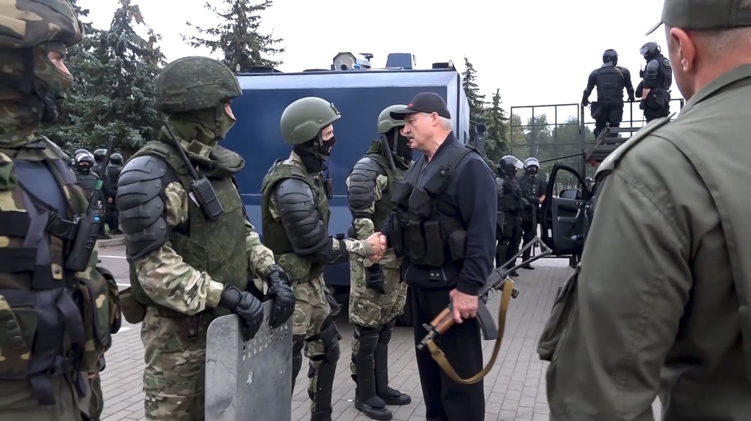 Alexandr Lukašenko ozbrojený s puškou Kalašnikov a v nepriestrelnej veste ďakuje policajtom pri Paláci nezávislosti v hlavnom meste Mink. Foto: TASR/AP