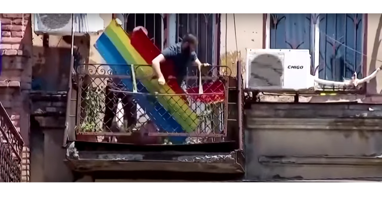 Demonštranti zhadzujú dúhový transparent z balkóna organizácie Tbilisi Pride v Gruzínsku. Foto: YouTube