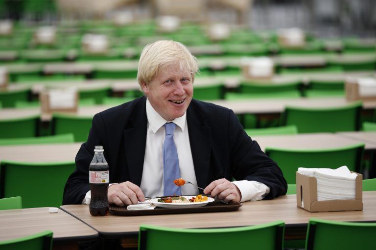 Boris Johnson, vtedajší londýnsky starosta, si pochutnáva na jedle v jedálenskej hale 12. júla 2012 v olympijskej a paralympijskej dedine v Londýne. Foto: TASR/AP