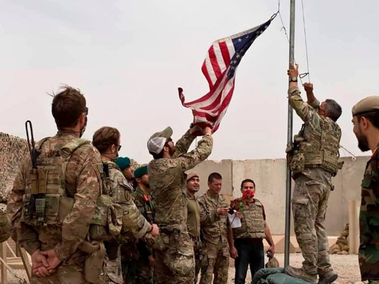 Spúšťanie americkej vlajky, keď americkí vojaci odovzdávajú techniku afganským bezpečnostným zložkám v provincii Helmand na juhu Afganistanu. Foto: TASR/AP