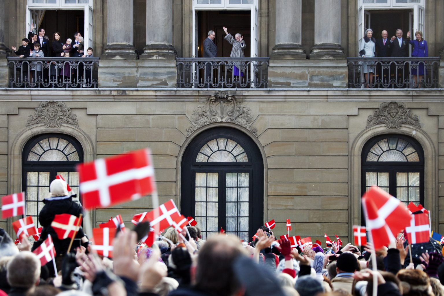 Dánska kráľovná Margaréta II. s princom Henrikom mávajú z prostredného balkóna kodanského paláca Amalienborg. Foto: TASR/AP