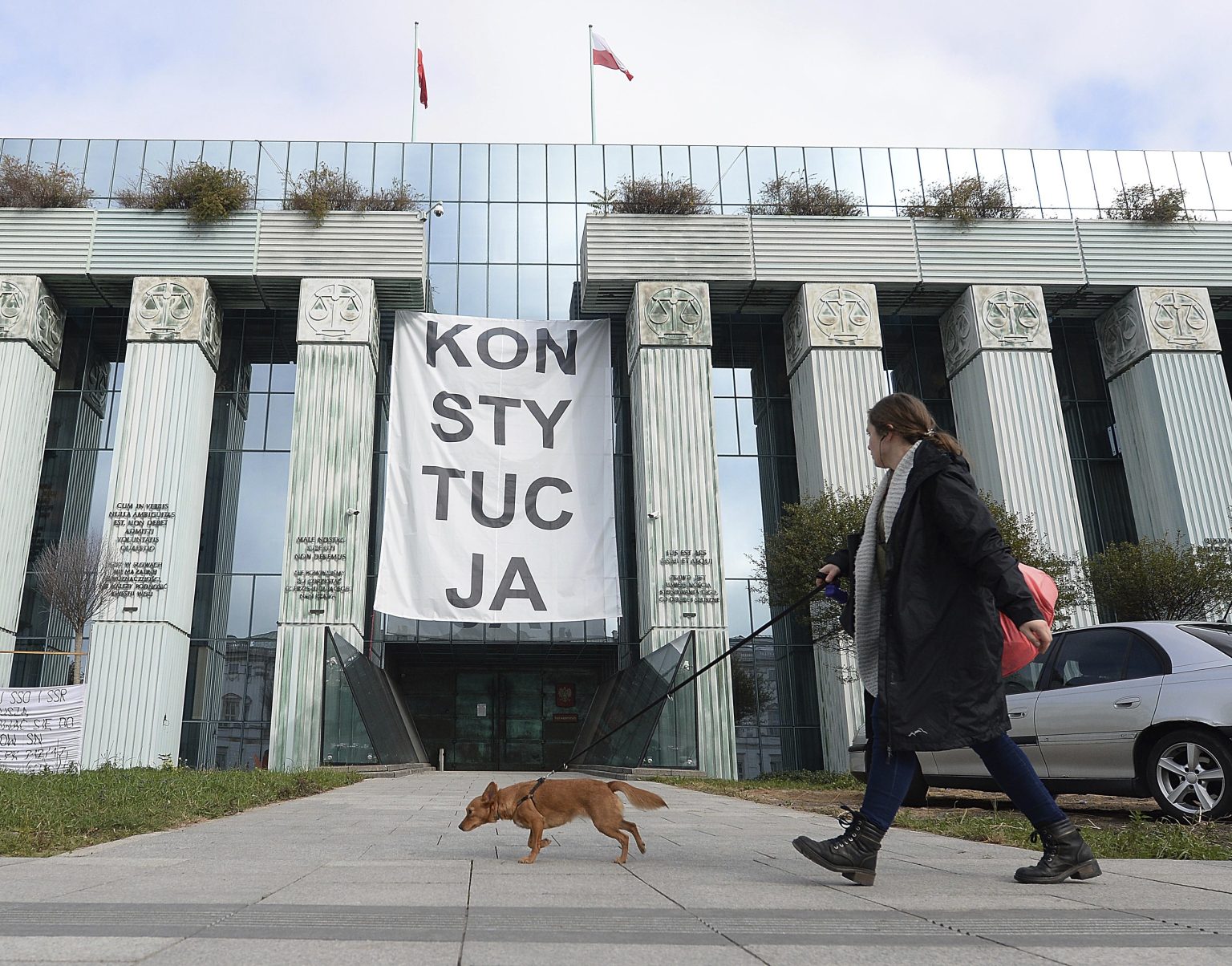 Žena venčí psa pri poľskom Najvyššom súde vo Varšave. Foto: TASR/AP