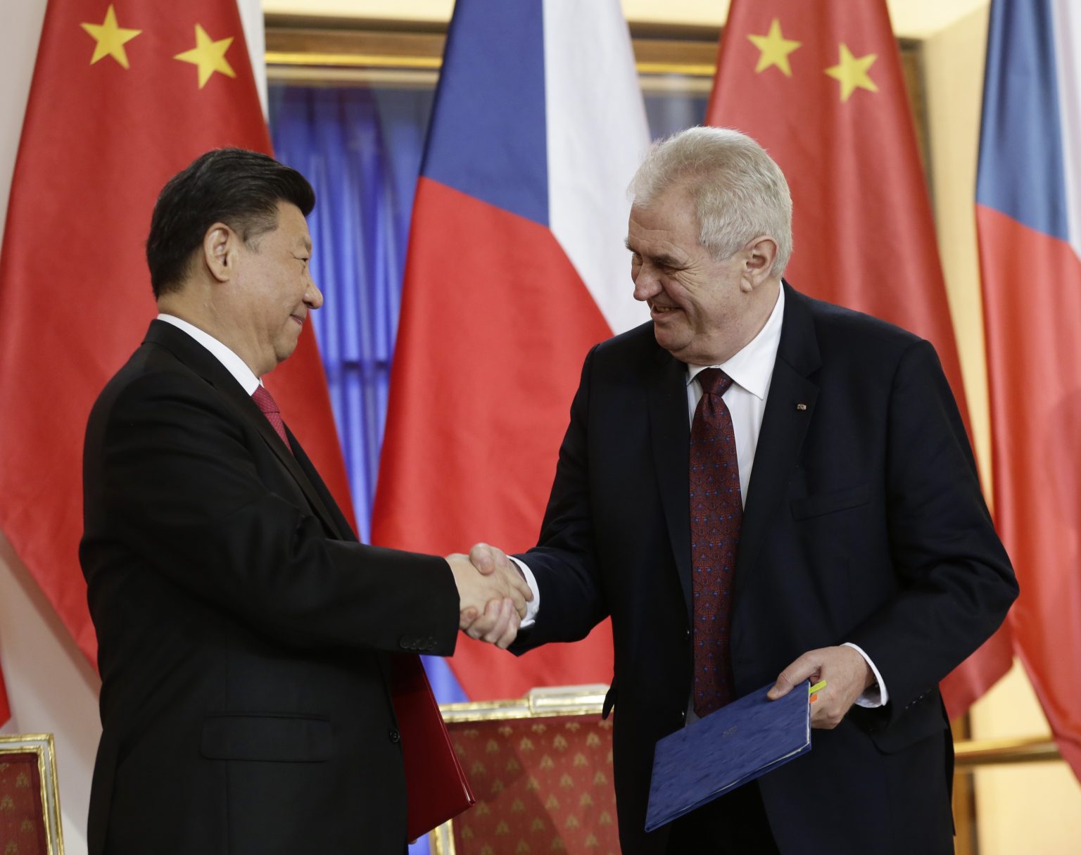 Čínsky prezident Si Ťin-pching (vľavo) a český prezident Miloš Zeman si podávajú ruky po podpise zmluvy o strategickej spolupráci na Pražskom hrade 29. marca 2016. Foto: TASR/AP