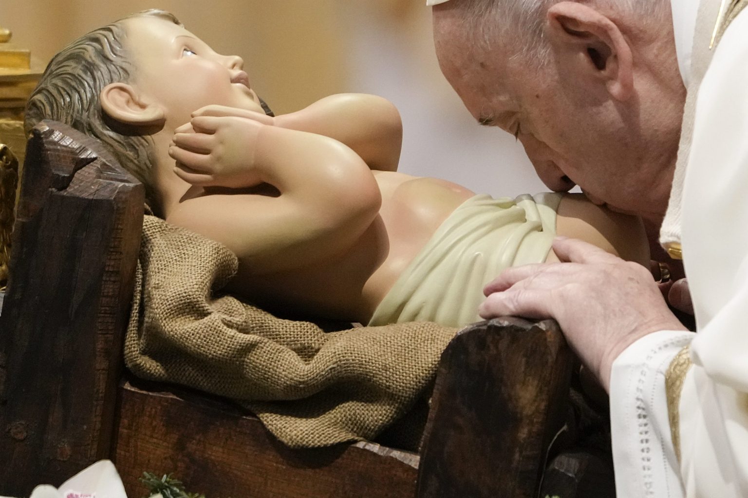 Pápež František bozkáva sochu jezuliatka počas celebrovania svätej omše k sviatku Zjavenie Pána - Traja králi v Bazilike sv. Petra vo Vatikáne. Foto: TASR/AP
