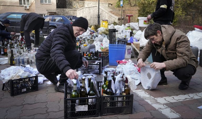 Na snímke príslušníci civilnej obrany pripravujú Molotovov koktail  27. februára 2022 v Kyjeve. Foto: TASR/AP