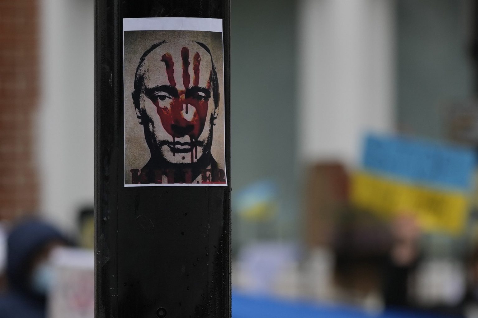 Plagát s krvavým odtlačkom dlane na tvári ruského prezidenta Vladimira Putina visí na stĺpe počas protestu proti vojne na Ukrajine pred budovou ruskej ambasády v Londýne. Foto: TASR/AP