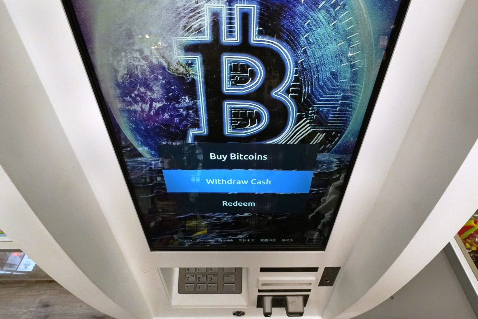 Logo bitcoinu svieti na obrazke bankomatu v americkom meste Salem. Foto: TASR/AP