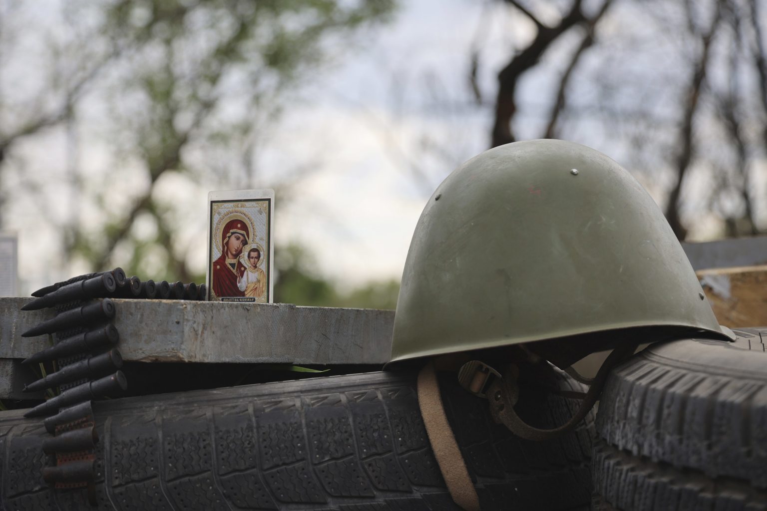 Obrázok ikony sa nachádza vedľa vojenskej prilby na kontrolnom stanovišti v obliehanom prístavnom meste Mariupol na juhovýchode Ukrajiny. Foto: TASR/AP