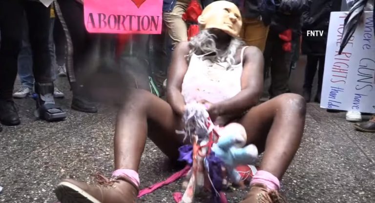 Propotratová aktivistka predvádzajúca nechutné divadlo pred Katedrálou sv. Patrika v New Yorku na deň matiek, 8.5.2022. Foto: reprofoto youtube