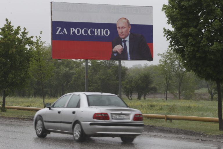 Auto prechádza okolo billboardu s portrétom ruského prezidenta Vladimira Putina a nápisom Za Rusko. Foto: TASR/AP