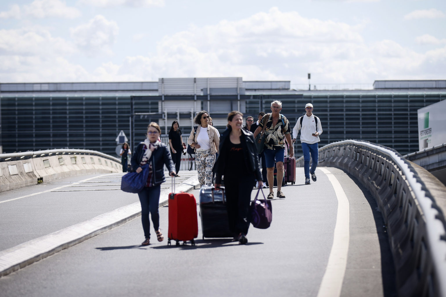 Cestujúci prichádzajú pešo na letisko Roissy - Charles de Gaulle, severne od Paríža 1. júla 2022 počas štrajku francúzskych odborárov na termináli. Foto: TASR/AP - Thomas Padilla