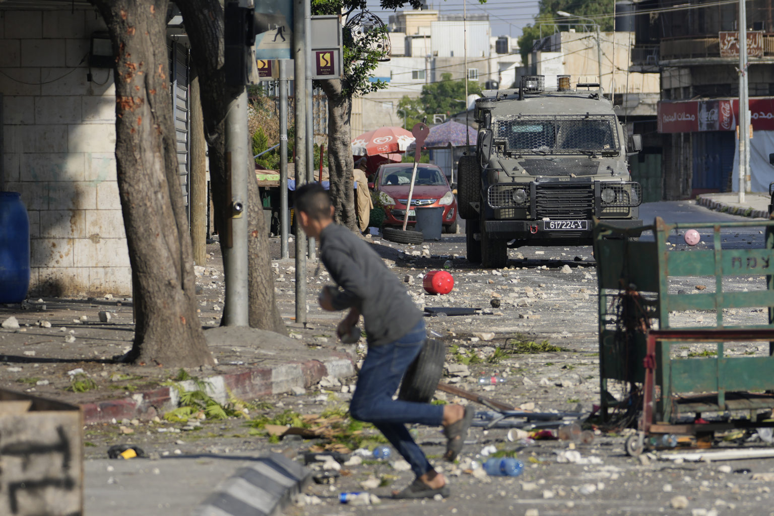 Palestínsky demonštrant drží kamene počas operácie izraelskej armády v meste Nábulus na Západnom brehu 9. augusta 2022. Foto: TASR/AP 