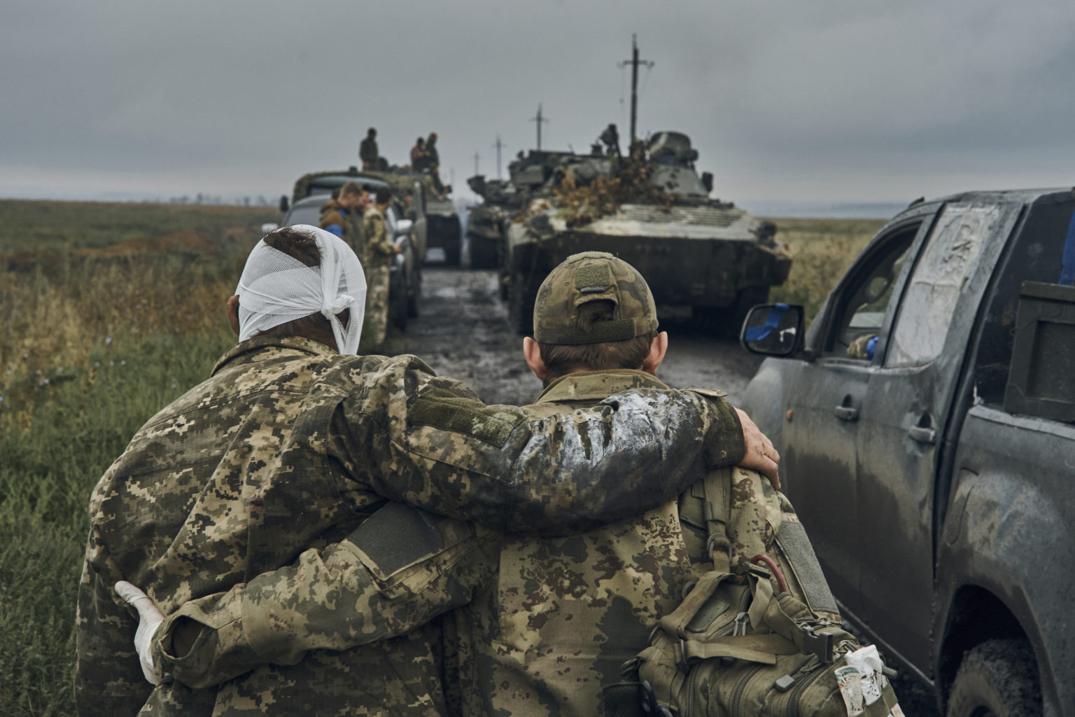 Na snímke ukrajinský vojak pomáha zranenému spolubojovníkovi. Foto: TASR/AP