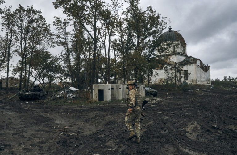 Ukrajinský vojak kráča  v ukrajinskom meste Izium v Charkovskej oblasti 13. septembra 2022. Foto: TASR/AP