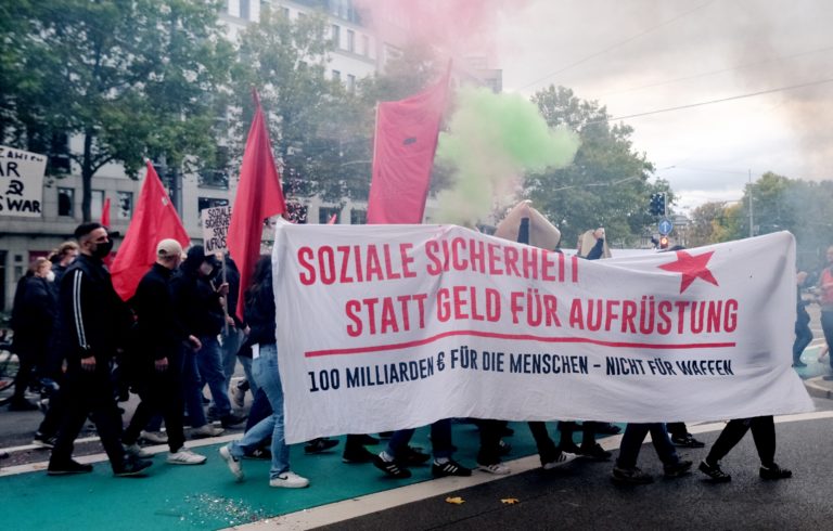 Na snímke účastníci protestu držia transparent, vlajky a zápalnú pyrotechniku počas demonštrácie proti rastúcim cenám energií a potravín v Lipsku 15. októbra 2022. Foto: TASR/DPA