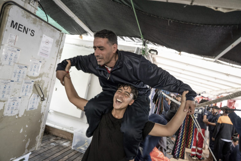 Na staršej snímke nelegálni migranti sa radujú na lodi Ocean Viking smerujúcej do Francúzska. Foto: TASR/AP