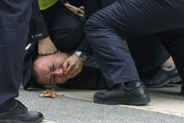 Čínski policajti zatýkajú demonštranta počas protestu proti covidovým opatreniam v čínskom Šanghaji 27. novembra 2022. Foto: TASR/AP