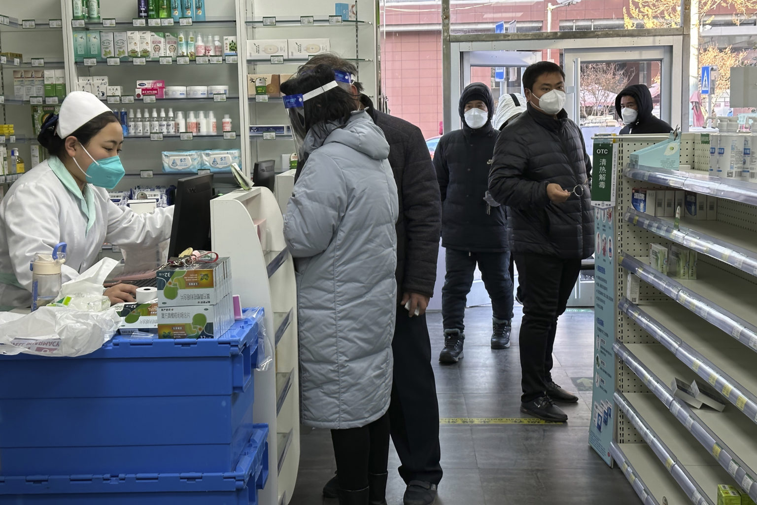 Farmaceutka obsluhuje zákazníčku pri prázdnych regáloch v lekárni. Foto: TASR/AP