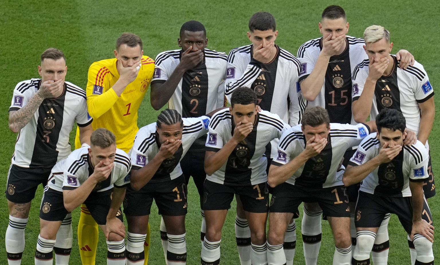 Nemeckí futbalisti si zakrývajú ústa na tímovej fotografii pred zápasom základnej skupiny. Foto: TASR/AP