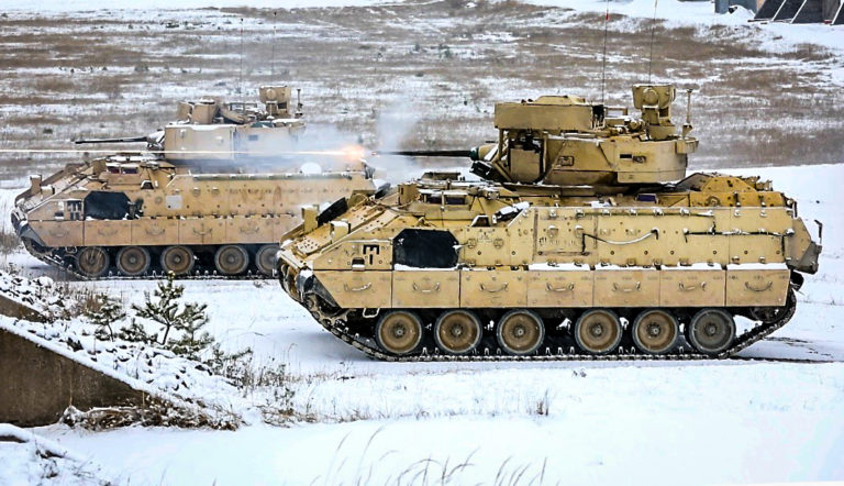 Dvojica bojových vozidiel pechoty Bradley M2A3 strieľa zo svojich kanónov pri nácviku ostrej streľby. Foto: Ronald Lee/Wikipedia