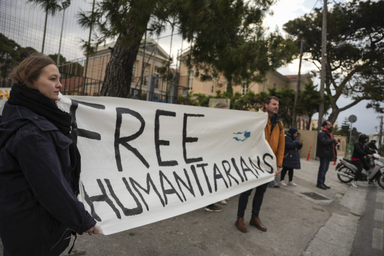 Na snímke podporovatelia 24 humanitárnych pracovníkov obvinených zo špionáže držia transparent pred budovou súdu v meste Mytilene na gréckom ostrove Lesbos 10. januára 2023. V Grécku sa v utorok obnovil proces s 24 humanitárnymi pracovníkmi obvinenými zo špionáže. Foto: TASR/AP