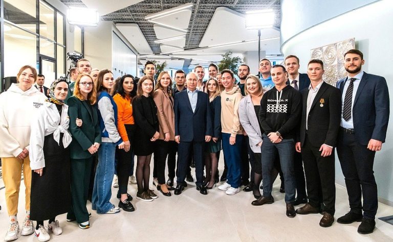 Putin na zvýšených opätkoch pózuje fotografom so študentmi. Foto: Russian Embassy in USA/Twitter