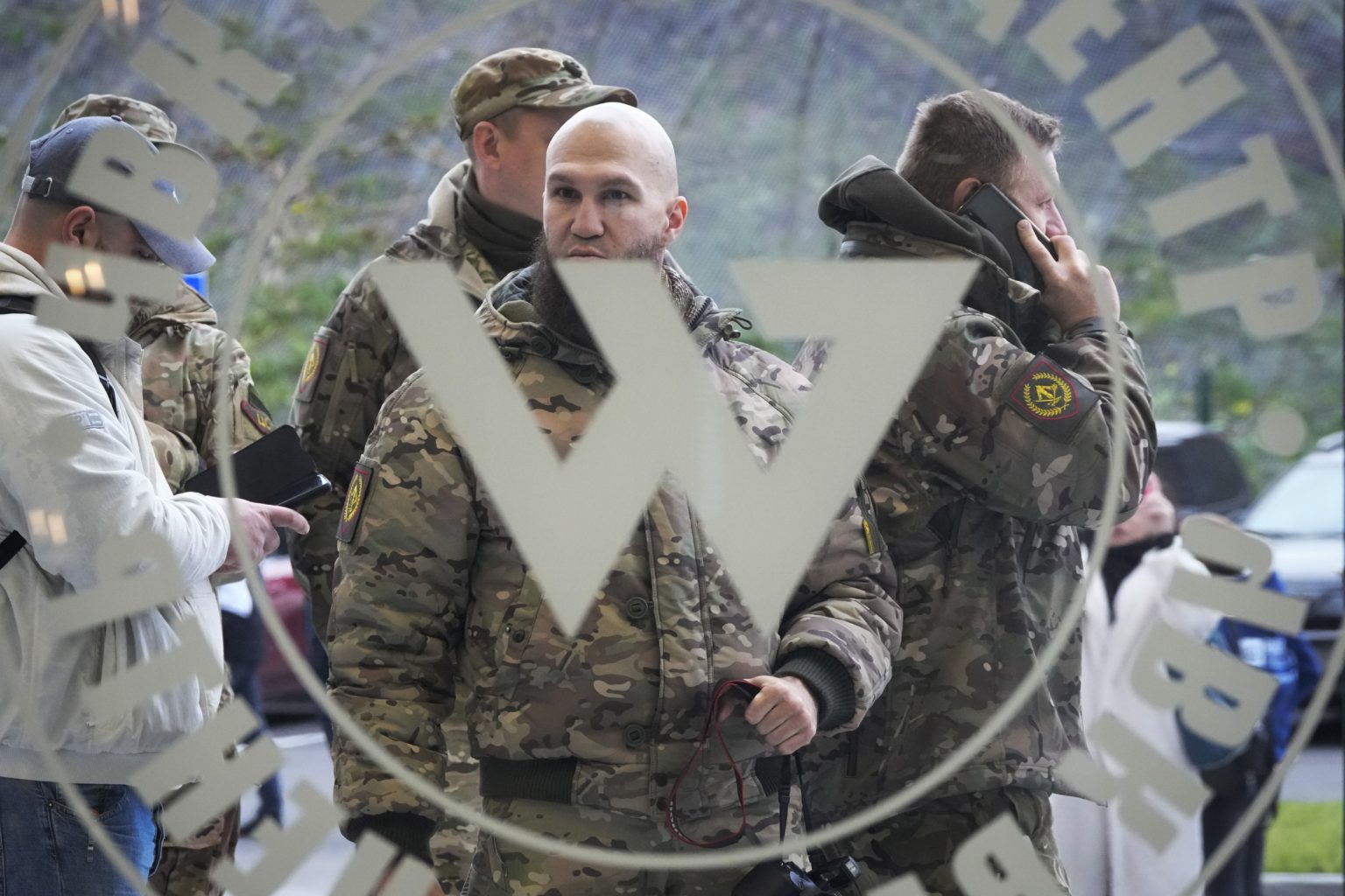 Návštevníci vo vojenských maskáčoch stoja pri vchode do Vagnerovho centra. Foto: TASR/AP