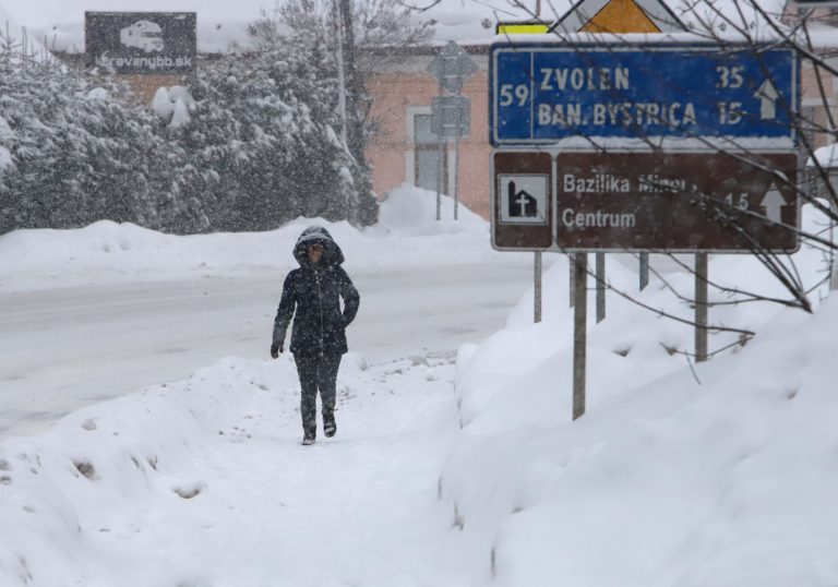 Žena kráča po chodníku počas sneženia v Starých Horách pri Banskej Bystrici. Foto: Ján Krošlák/TASR