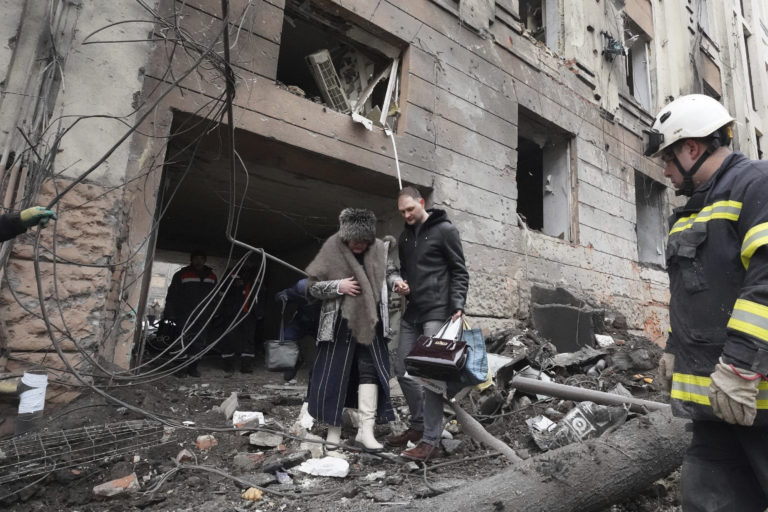 Muž pomáha vyjsť žene z obytnej budovy, ktorá sa stala terčom ruského ostreľovania v ukrajinskom meste Charkov. Foto: TASR/AP