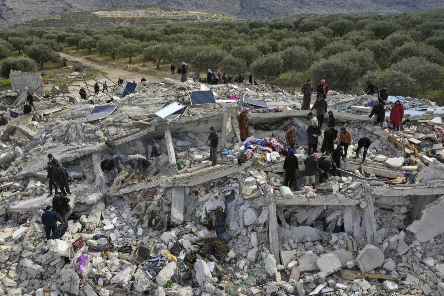 Pracovníci civilnej obrany a obyvatelia prehľadávajú ruiny zrútených budov v meste Harem pri tureckých hraniciach v sýrskej provincii Idlib 6. februára 2023. Foto: TASR/AP