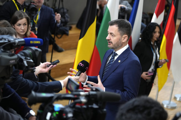 Slovenský premiér Eduard Heger sa rozpráva s médiami pri príchode na samit EÚ do budovy Európskej rady v Bruseli vo štvrtok 9. februára 2023. Foto: TASR/AP