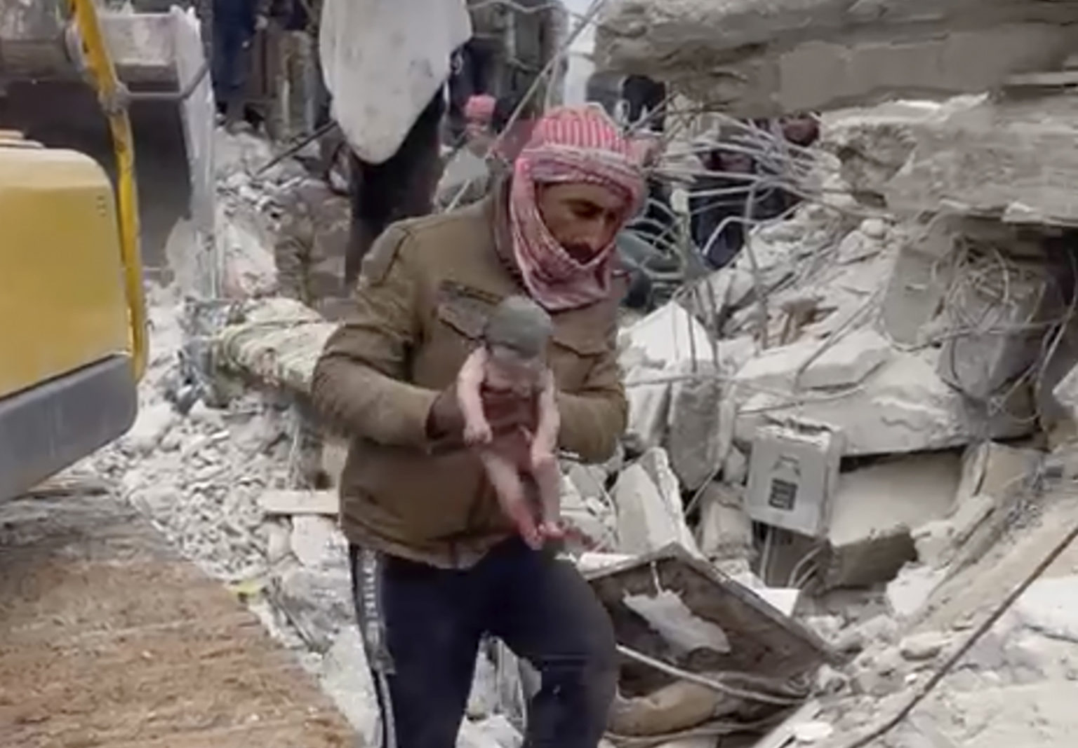 Záchranár drží novorodenca, ktoré vytiahli z trosiek budovy, ktorá sa zrútila v dôsledku ničivého zemetrasenia v meste Džindíras v provincii Aleppo. Foto: TASR/AP