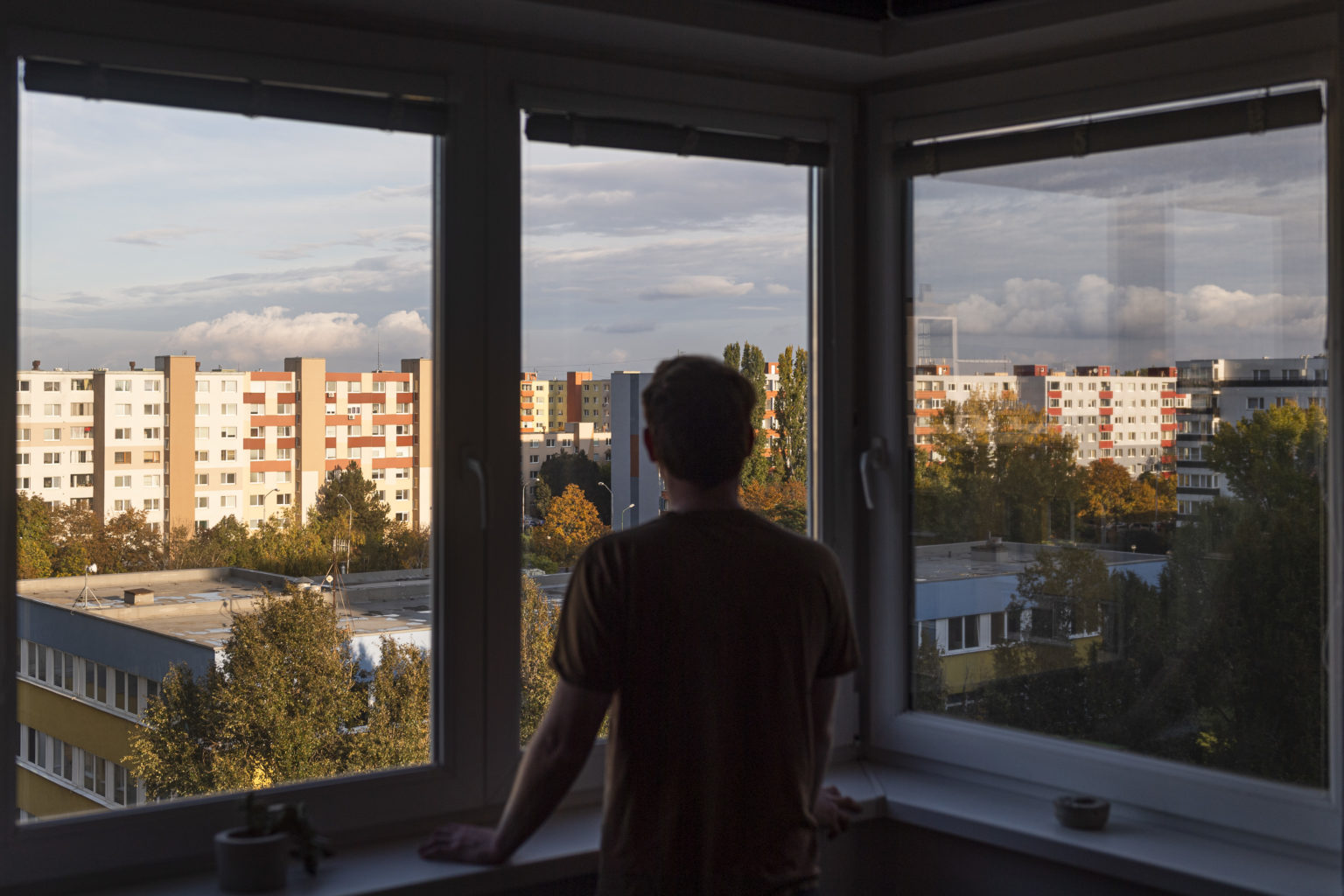Na snímke muž sa pozerá na ulicu z okna bytu v bratislavskej mestskej časti Podunajské Biskupice v sobotu 24. októbra 2020. Foto: Jaroslav Novák/TASR