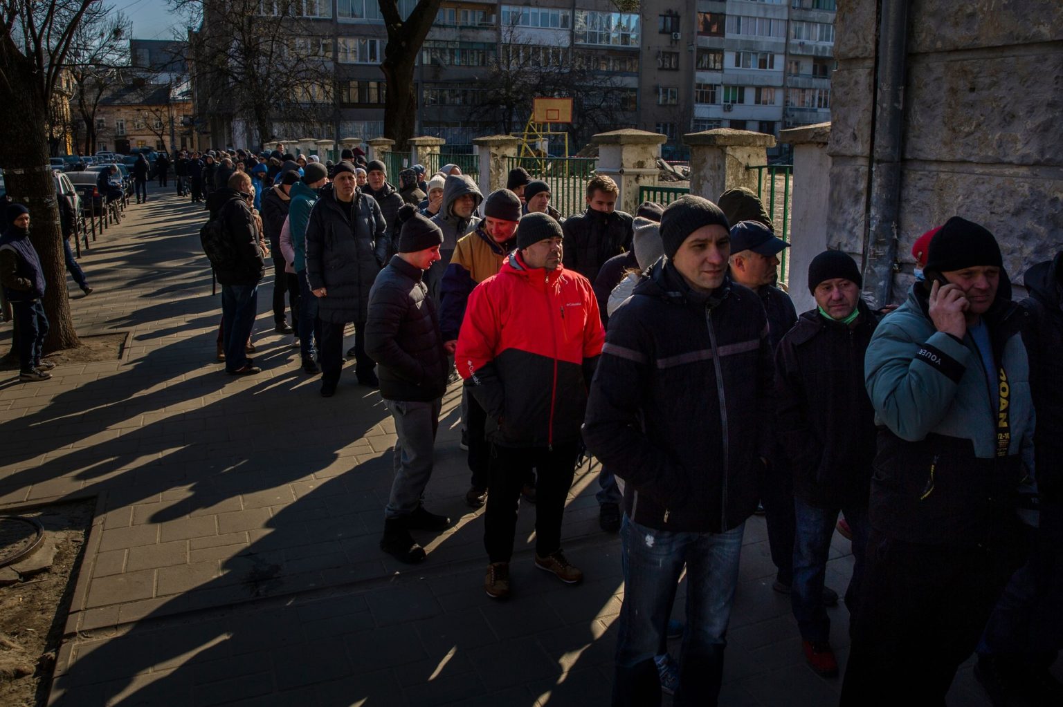Ukrajinskí muži čakajúci v rade pred odvodovým strediskom v Ľvove v marci 2022. Foto: Profimedia