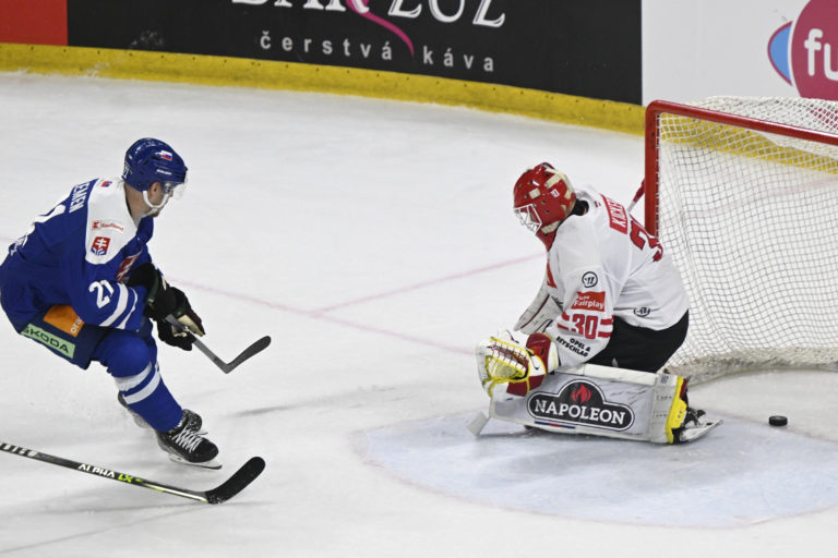 Miloš Kelemen (Slovensko) prekonáva brankára Davida Kickerta (Rakúsko) v prípravnom hokejovom zápase Slovensko - Rakúsko v Trenčíne. Foto: Radovan Stoklasa/TASR