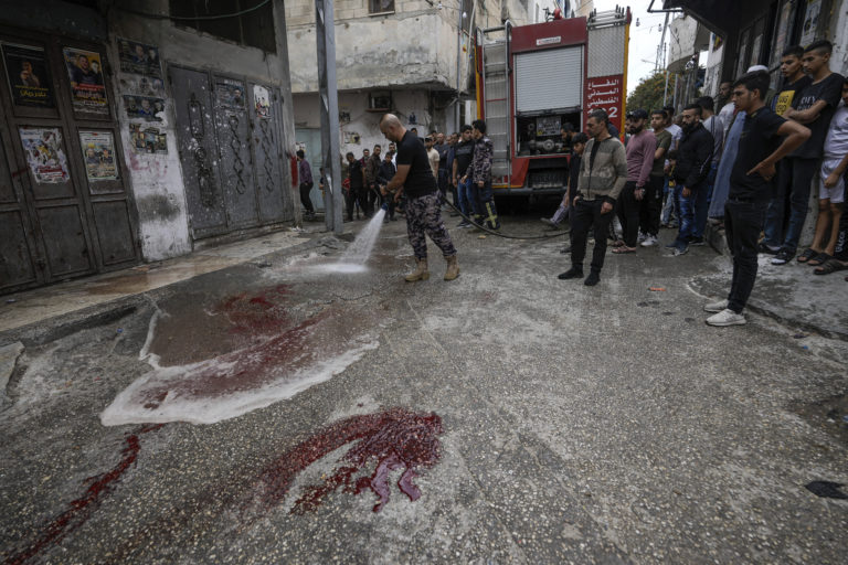 Palestínski hasiči odstraňujú stopy krvi na mieste, kde zahynuli dvaja Palestínčania počas razie izraelskej armády v utečeneckom tábore Balata pri Nábuluse na Západnom brehu Jordánu. Foto: TASR/AP