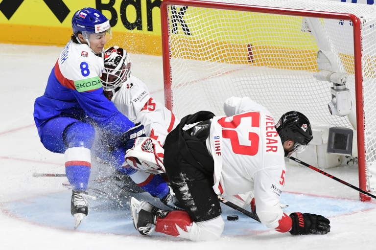 Na snímke uprostred brankár Kanady Samuel Montembeault, vpravo jeho spoluhráč a obranca MacKenzie Weegar, vľavo slovenský útočník Martin Chromiak v zápase Slovensko - Kanada v základnej B- skupine na 86. majstrovstvách sveta v ľadovom hokeji v pondelok 15. mája 2023 v lotyšskej Rige. Foto: Martin Baumann/TASR